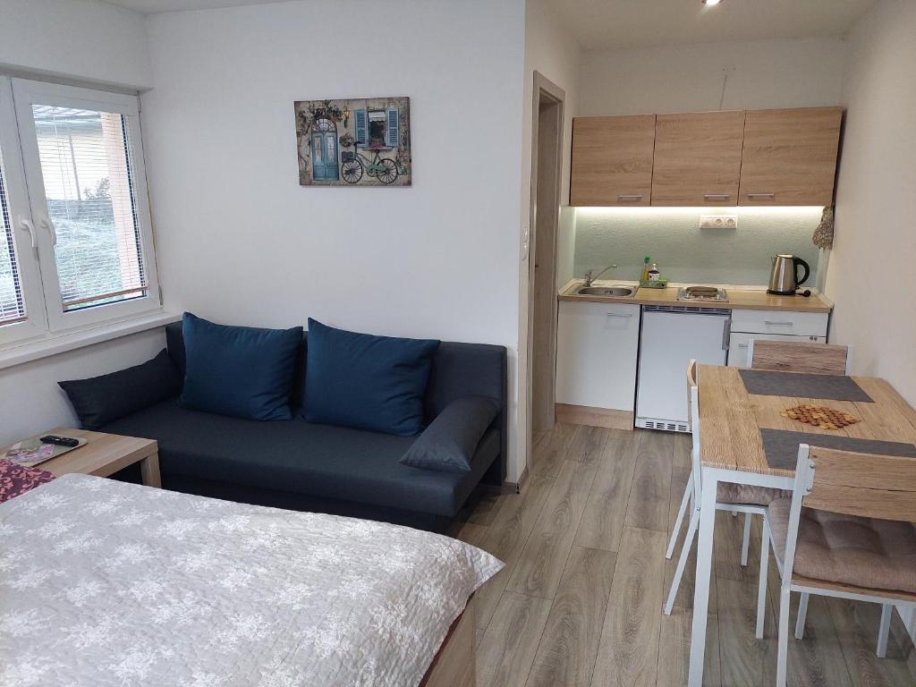 a living room with a blue couch and a table at BIKE apartments 2 in Hodruša