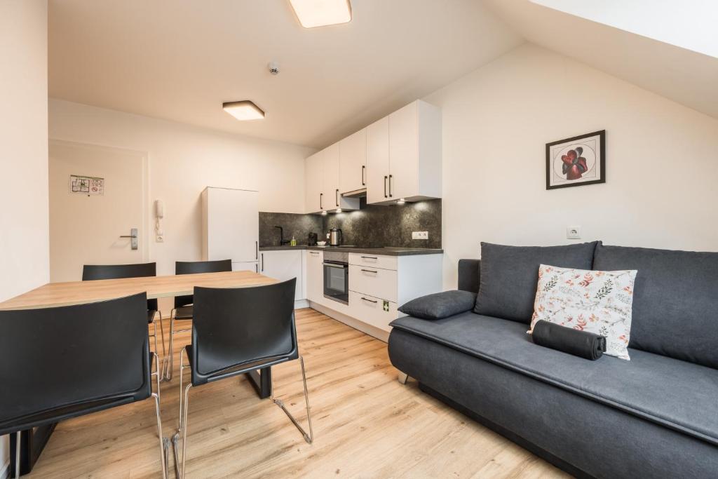 a living room with a couch and a table at myQuartier Central City Suites in Innsbruck