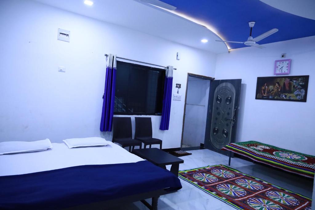 a room with two beds and a flat screen tv at EAGLE NEST FAMILY HOUSE in Bhuj