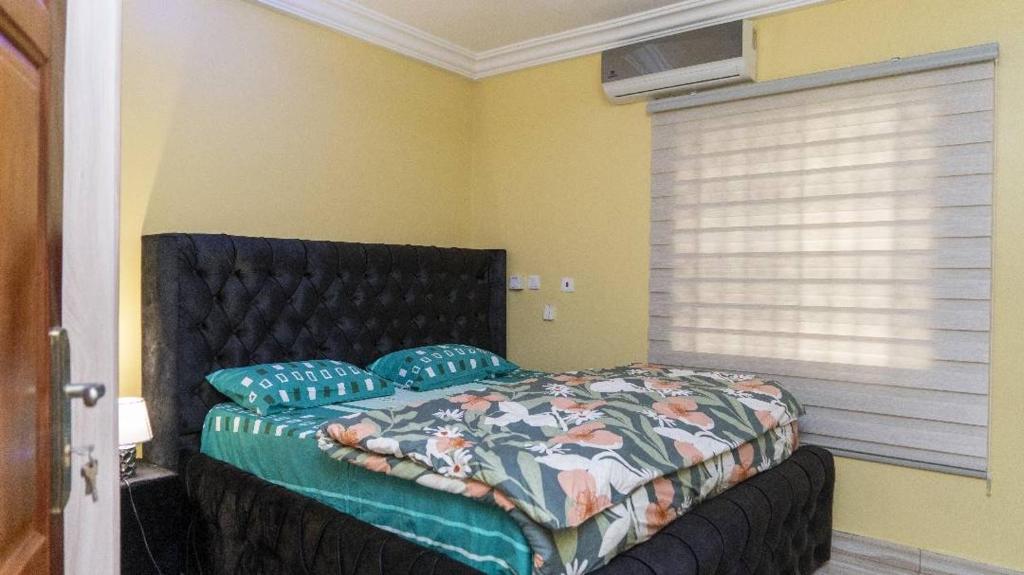 a bedroom with a bed with blue pillows at Obec’s Apartment in Accra