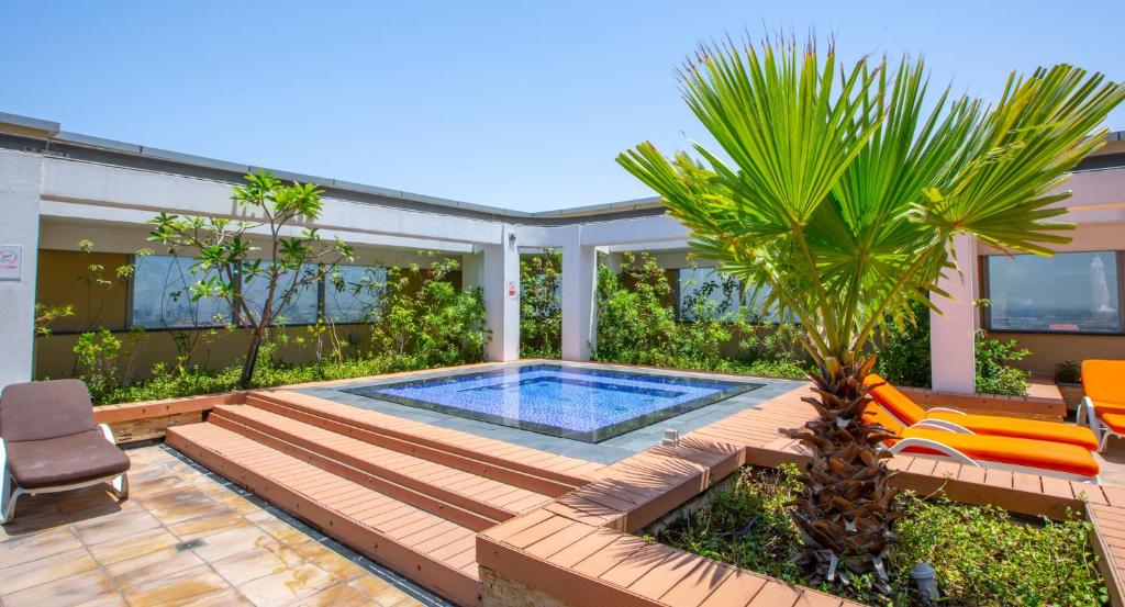 um quintal com uma piscina e uma palmeira em Best Spacious 1BR at Sky Gardens DIFC em Dubai