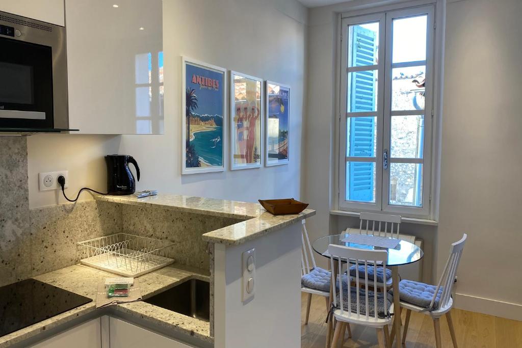 a kitchen with a counter and a table and chairs at Apartment Matisse 100Mt Near The Sea - Happy Rentals in Antibes