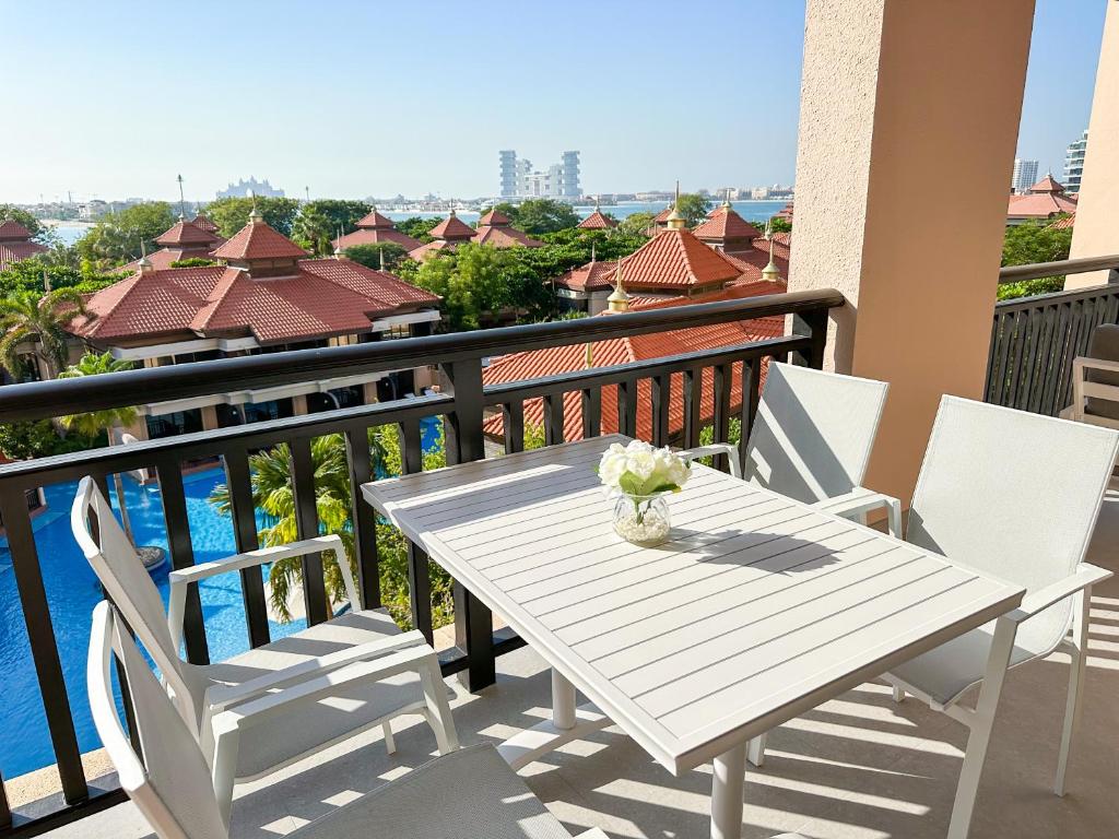 a white table and chairs on a balcony at Fabulous 2BR Apartment at 5 Star Resort in Dubai