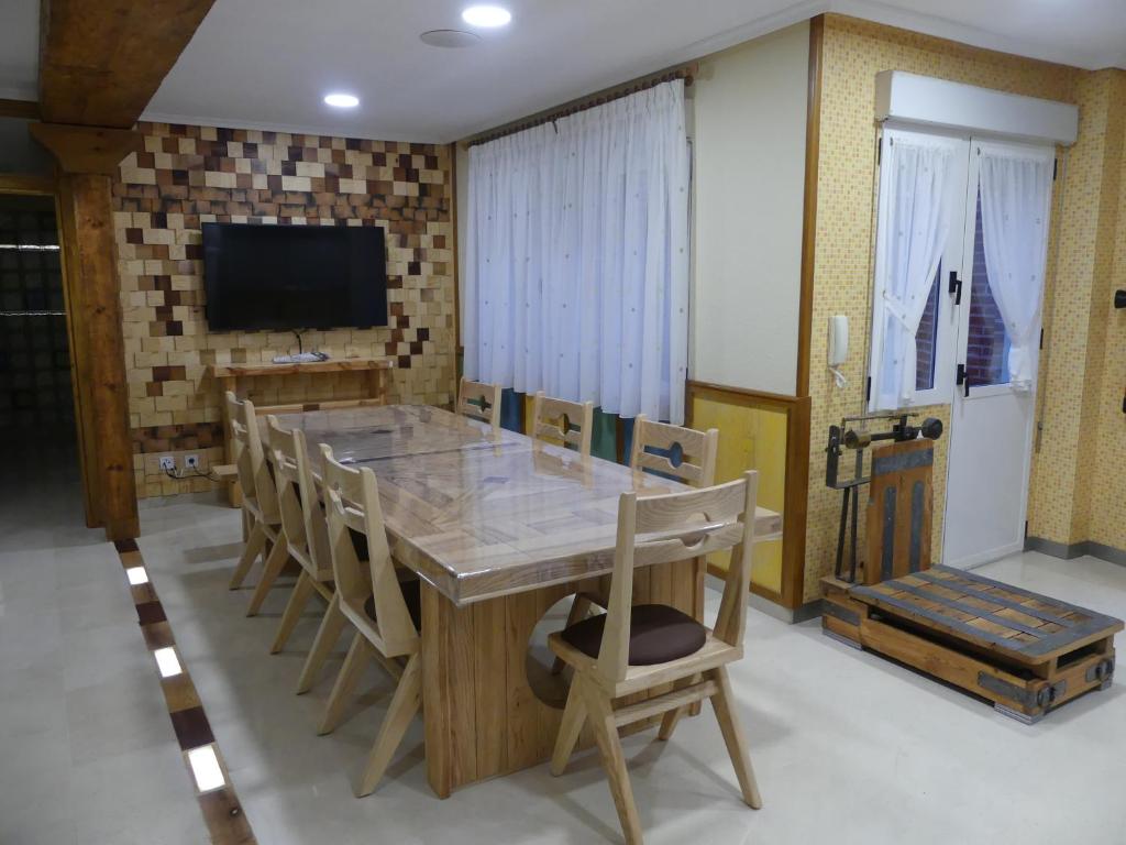 uma sala de jantar com uma grande mesa de madeira e cadeiras em Casa Felicitas Medina em Medina del Campo