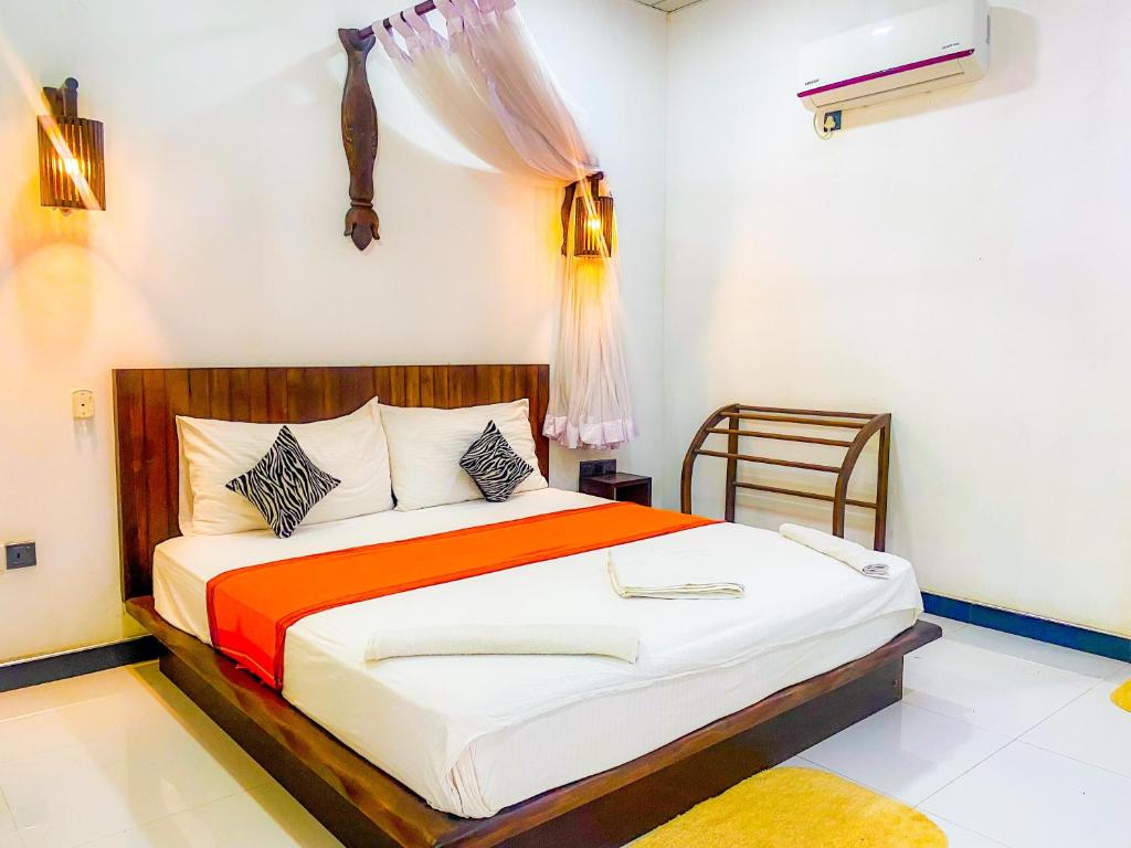 錫吉里亞的住宿－Sigiri Sunrise Villa，一间卧室配有一张带橙色毯子的大床