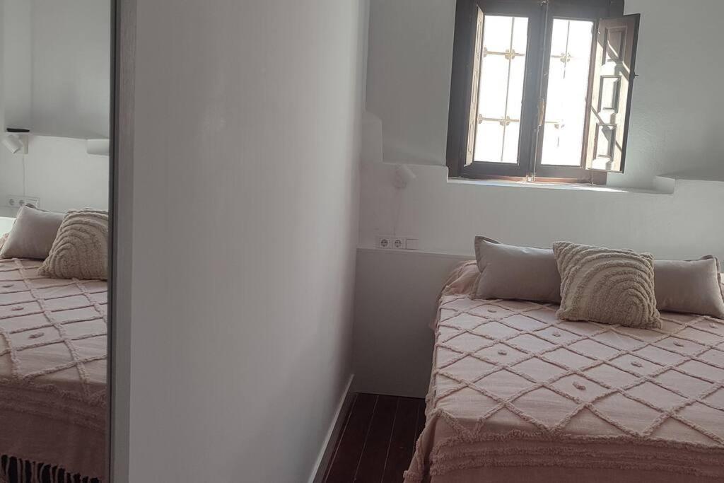 um quarto com 2 camas e uma janela em Tu casa em Almeria