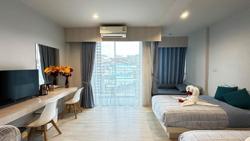 a bedroom with two beds and a desk and a tv at AURIFLEX HOUSE in Krabi town