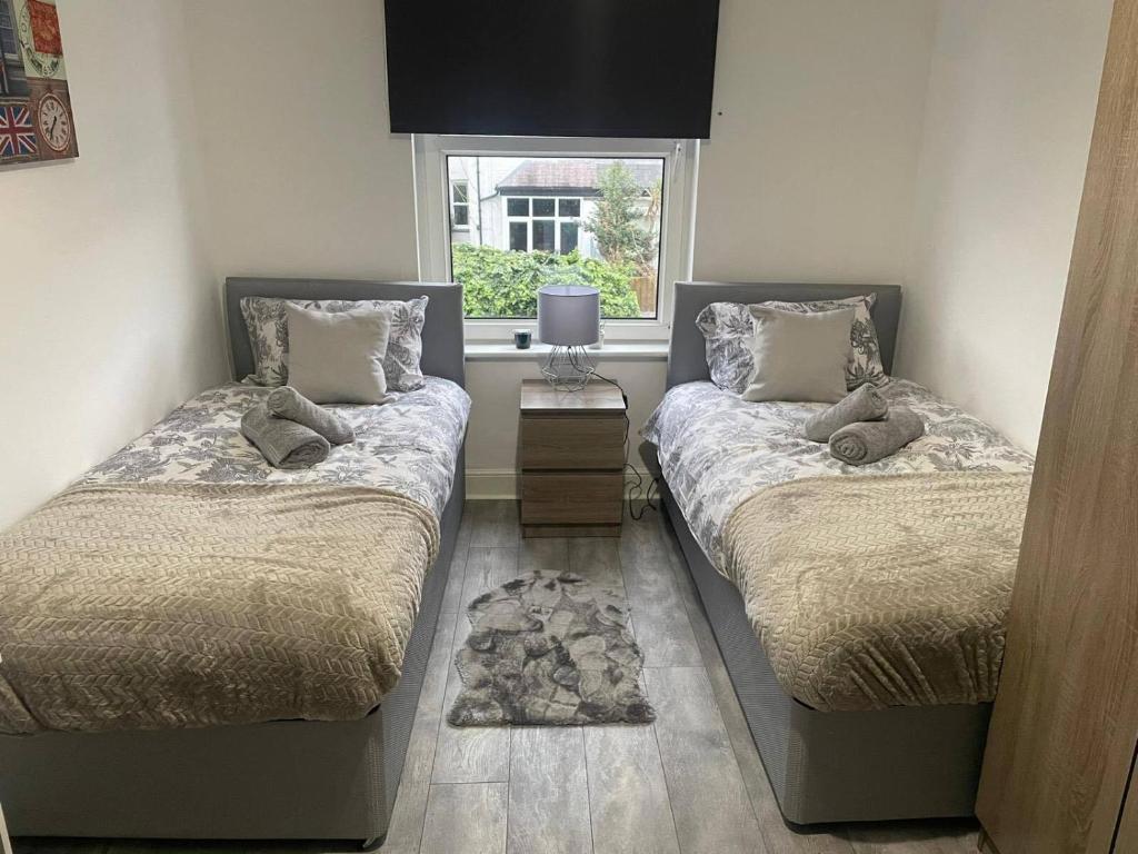 Duas camas num quarto com uma janela em Abington Park 5 Bedrooms with en-suite em Spinney Hill