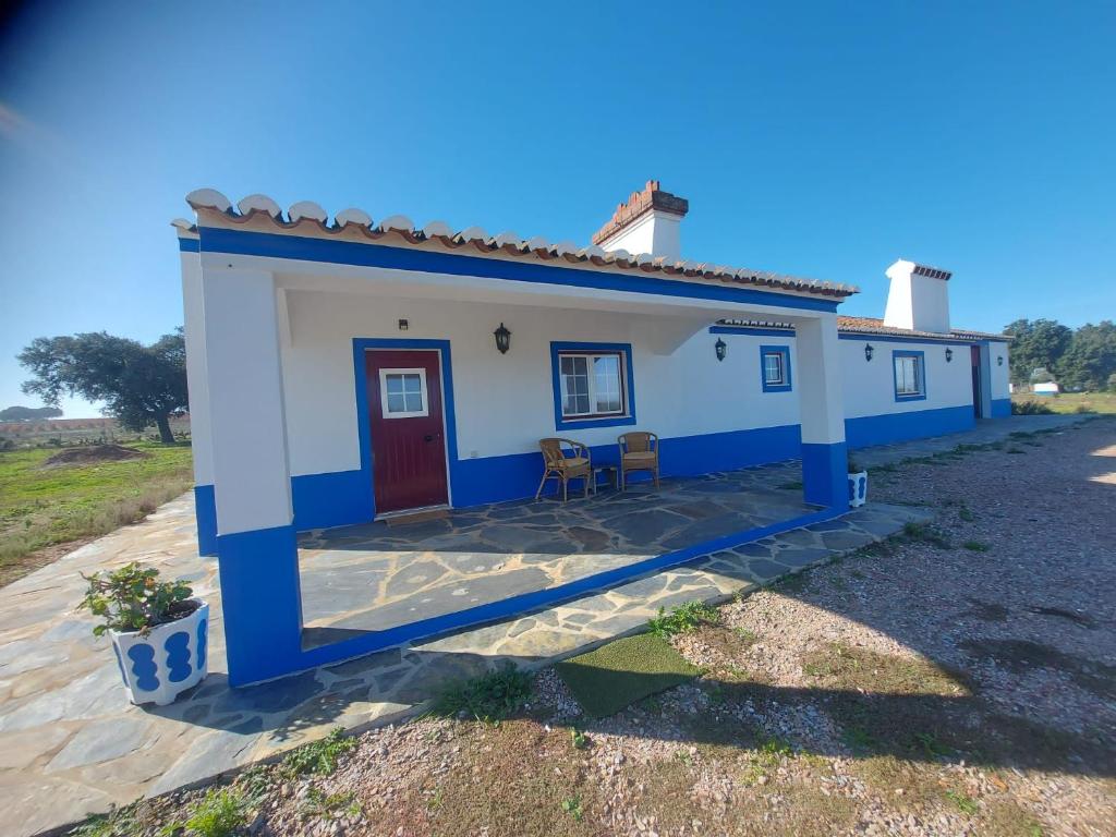 Quinta do Mocho في Arcos: بيت صغير ازرق وبيض مع باب احمر