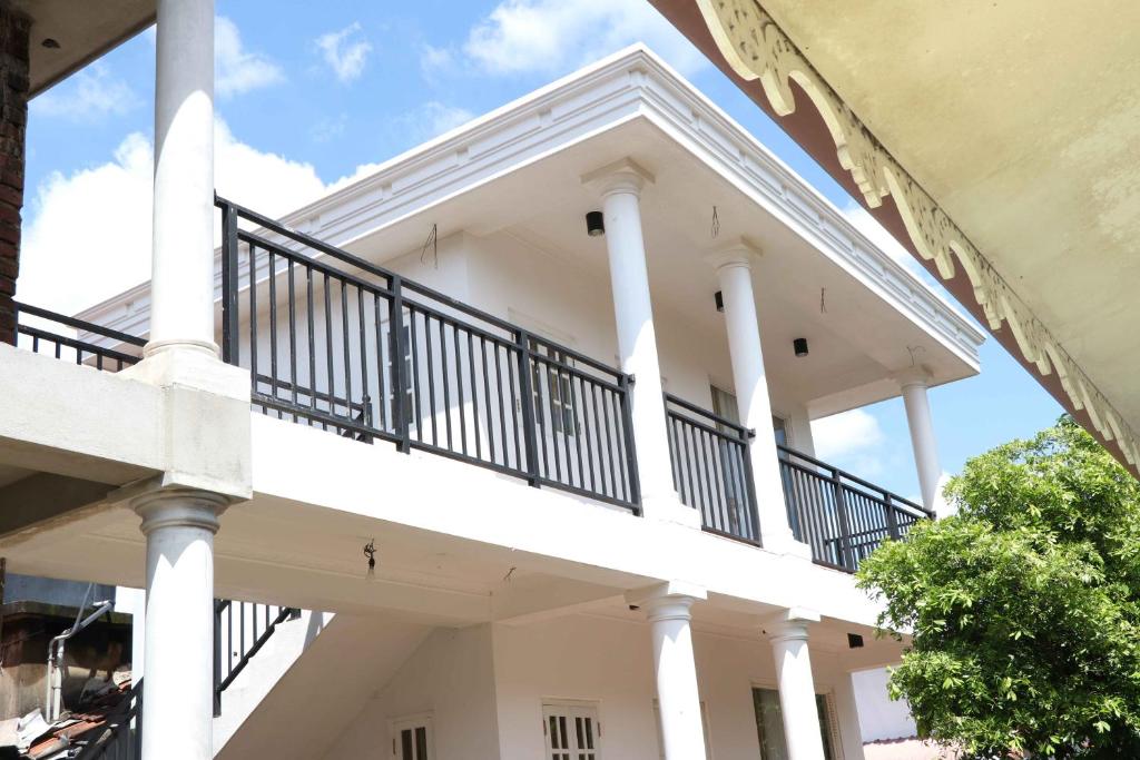 ein weißes Gebäude mit weißen Säulen und einem Balkon in der Unterkunft Illumination Stay in Negombo