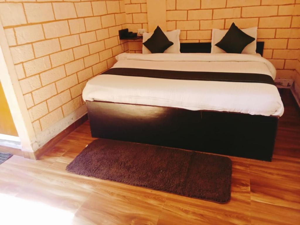 a bedroom with a large bed with a rug at Manikarn Resort in Joshīmath