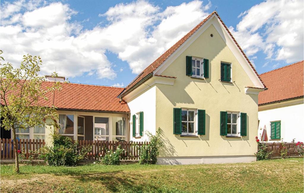 una casa con persianas verdes y una valla de madera en Lovely Home In Bad Waltersdorf With House A Panoramic View, en Bad Waltersdorf