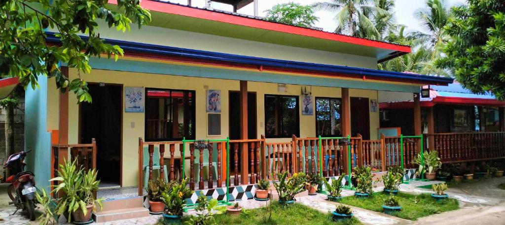 a house with potted plants in front of it at Hadefe Resort in El Nido