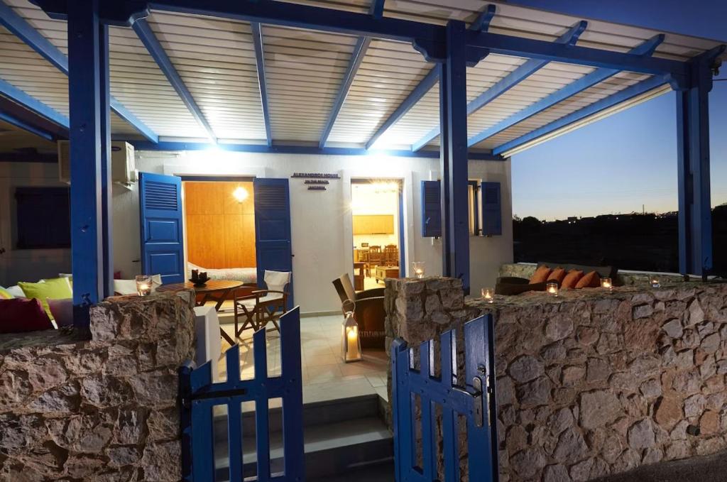 ein offenes Tor zu einem Haus mit einer Steinmauer in der Unterkunft Alexandros House in Monolithos