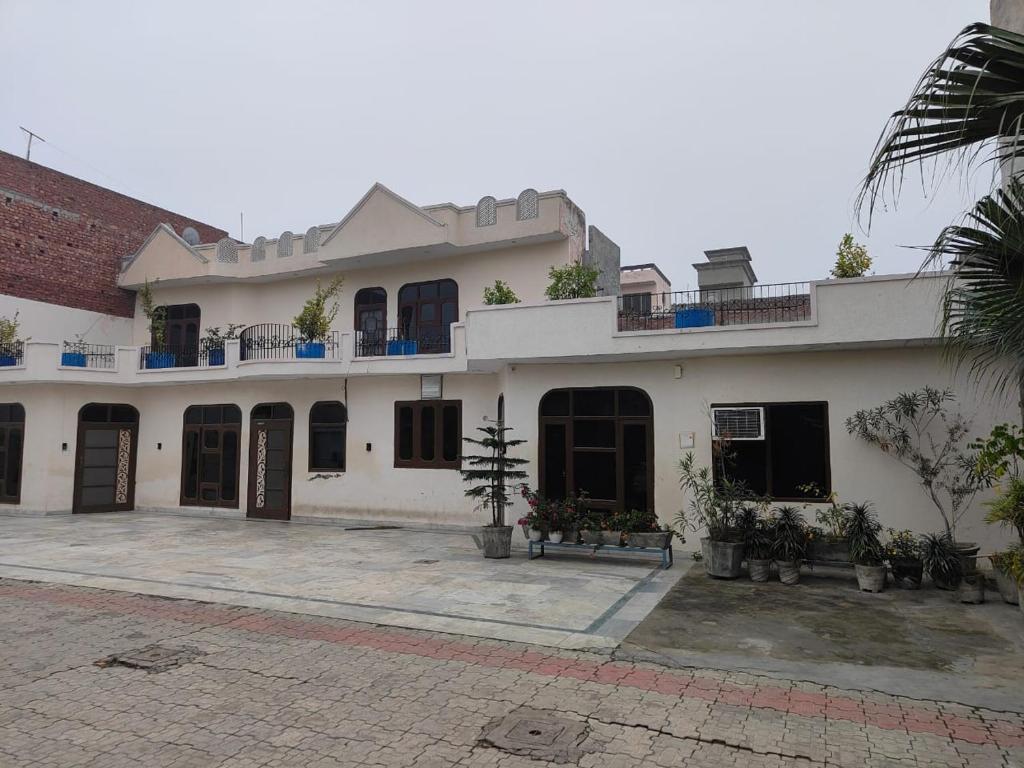 a large white building with a lot of windows at JS Farm Inn (By The Palm Tree - Family Stay) in Amritsar