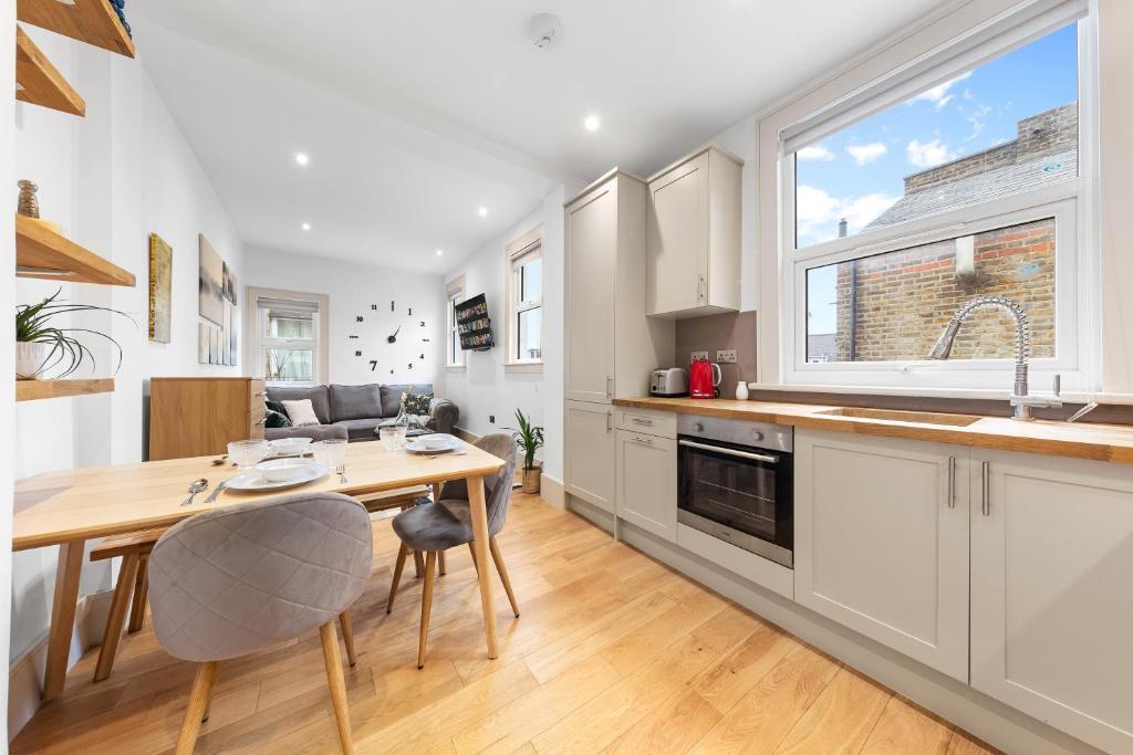 a kitchen with a table and chairs and a dining room at Modern Spacious 1 Bed Flat near Richmond Park in London