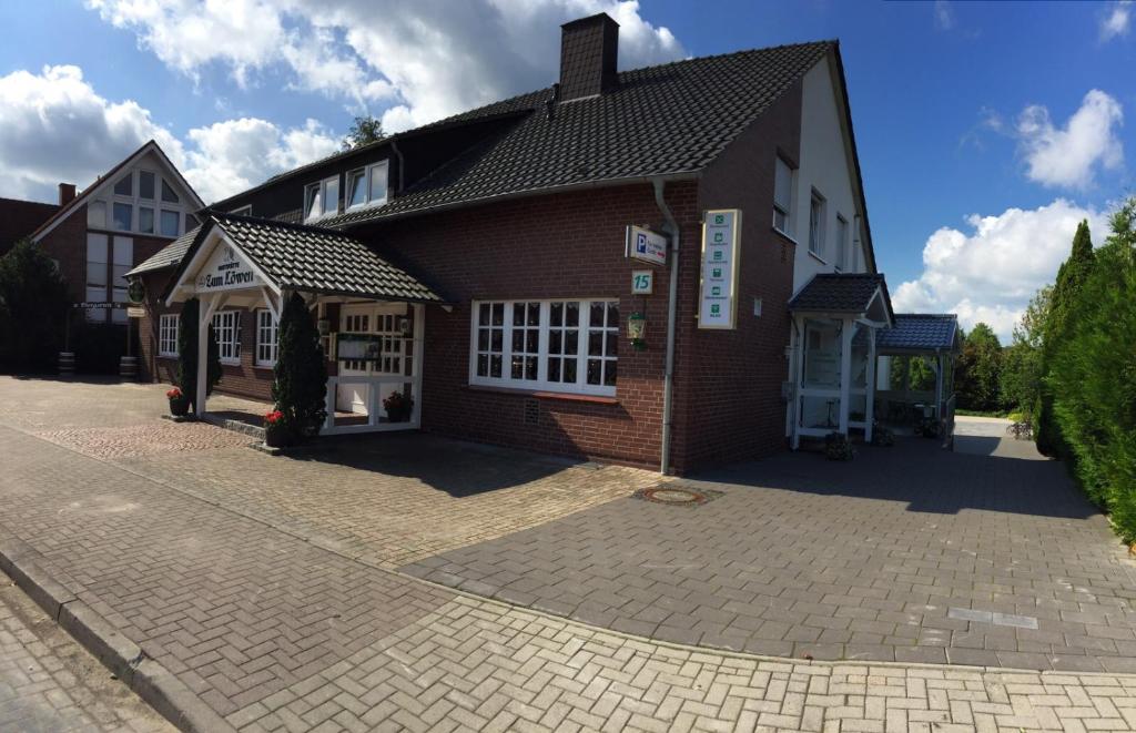 a large brick building with a brick driveway at Venner Gasthaus in Ostercappeln