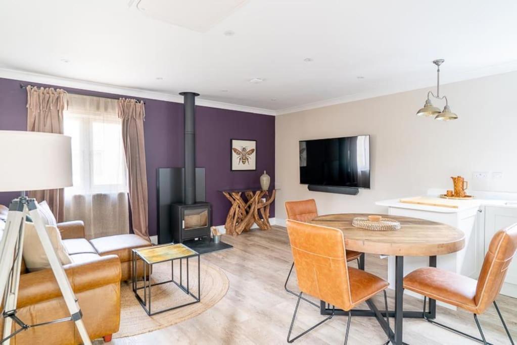 a living room with a table and a couch at Hideaway Cottages - Greenacres Estates in Tenby