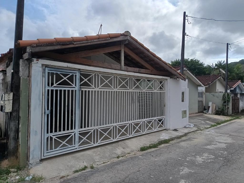 ein weißes Gebäude mit einem Tor auf einer Straße in der Unterkunft Espaço Casa Branca in Caraguatatuba