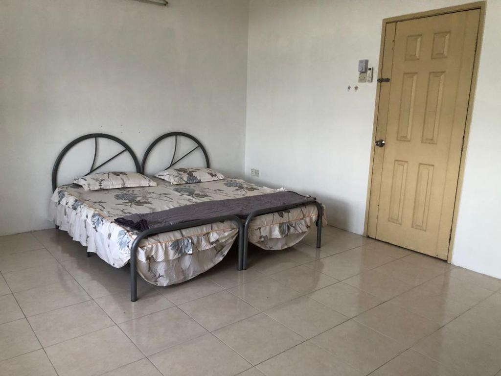 1 cama en una habitación con puerta en Padusi Homestay en Kampar
