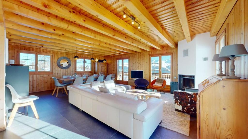 a living room with a large white couch and chairs at Narnia SKI IN & SKI OUT chalet 14 pers in Les Collons