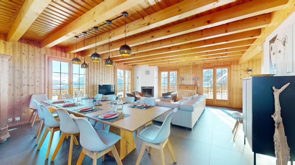 a dining room with a long table and chairs at Narnia SKI IN & SKI OUT chalet 14 pers in Les Collons