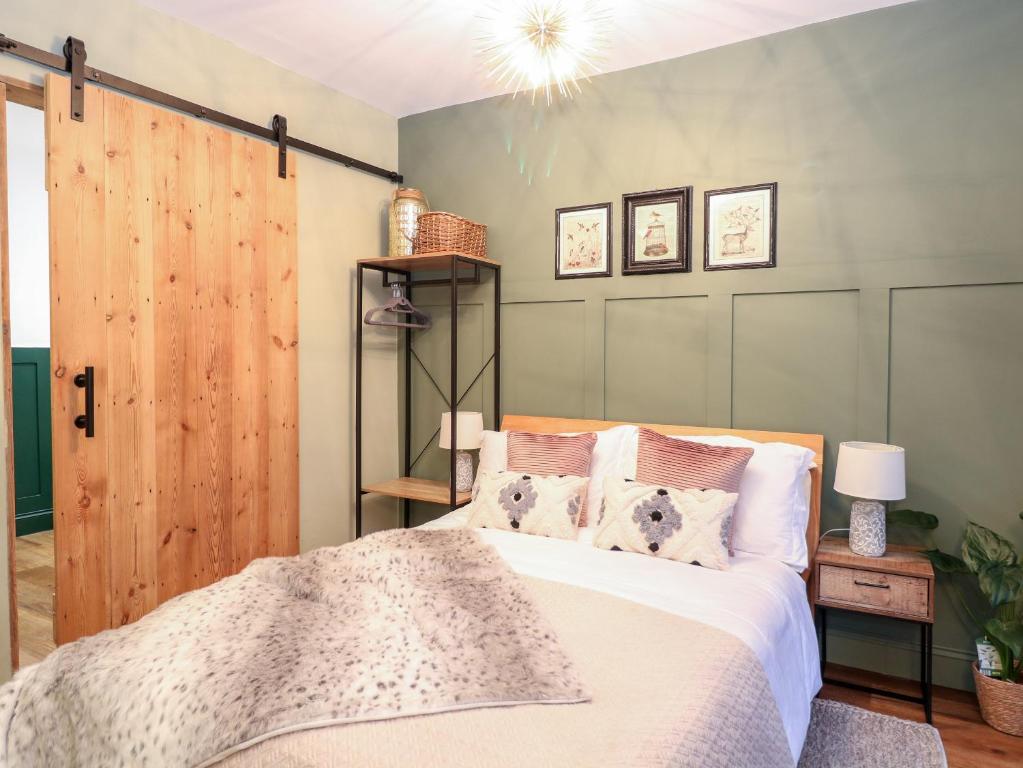 een slaapkamer met een bed en een houten deur bij Goldcrest Hide in Bungay