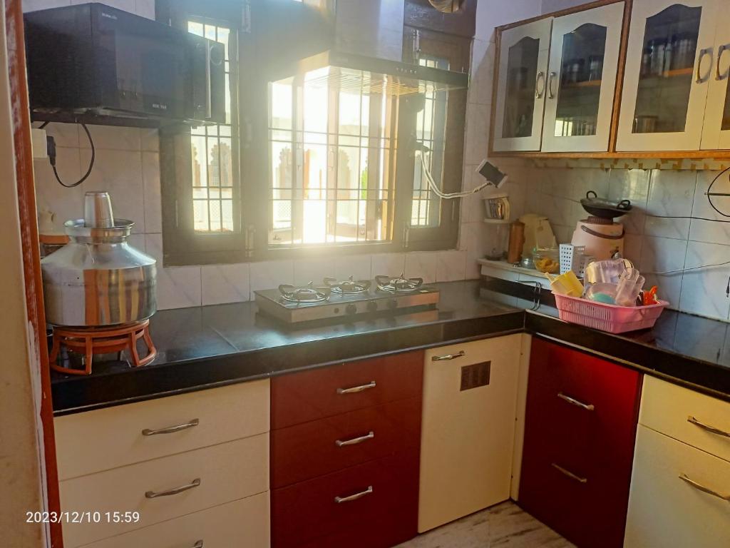 a kitchen with wooden cabinets and a counter top at Gokulam Villa in Udaipur