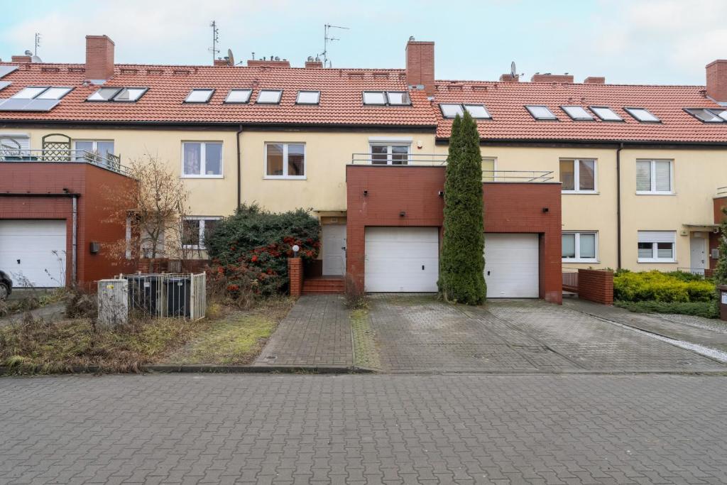 uma casa com duas portas de garagem e uma entrada em Dom Sianowska 130 m2, Parking & 3 Balkony Poznań by Renters em Poznań