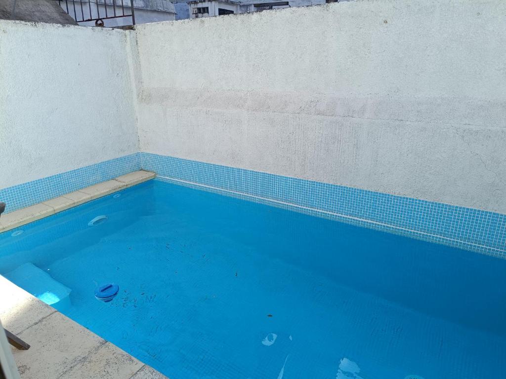 a swimming pool with blue water in front of a wall at Casa 2 dormitorios Montevideo Pocitos in Montevideo