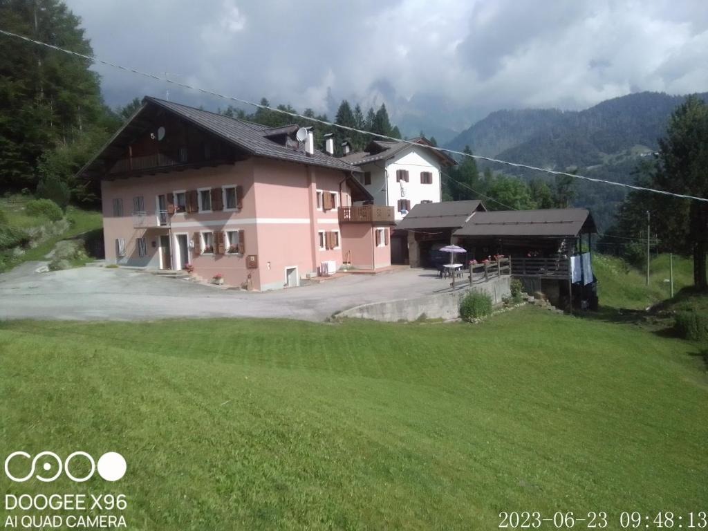 una casa con un campo verde davanti di B&B SòT AL PIZ a Sagron Mis