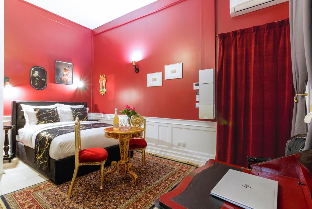 a red bedroom with a bed and a desk at La Flûte enchantée in Troyes