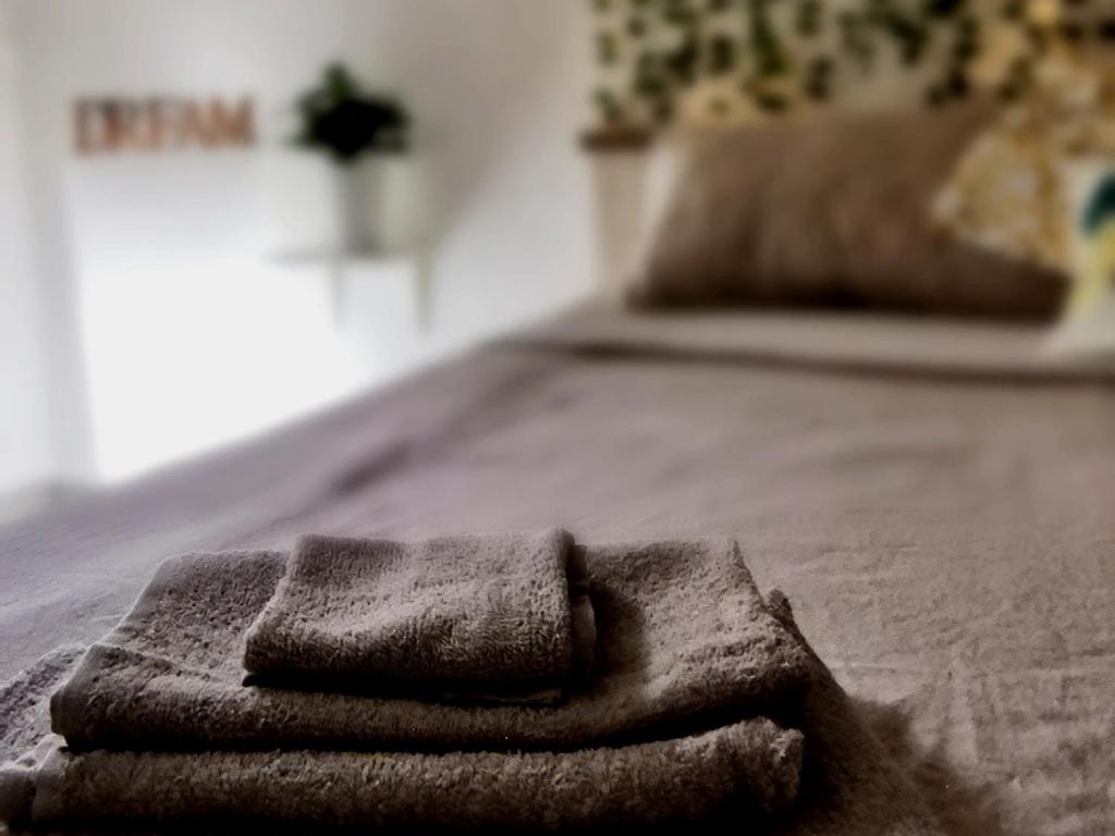 uma pilha de toalhas sentadas numa cama em Soraya apartment em Catânia
