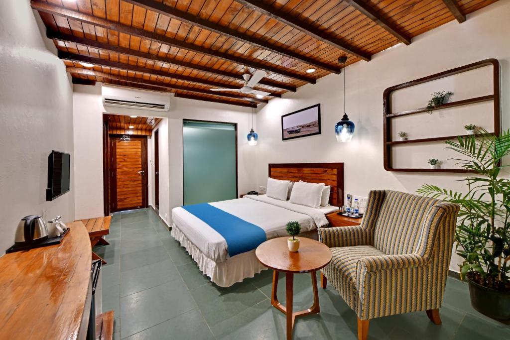 a hotel room with a bed and a table and chairs at The Fern Leo Beach Resort , Madhavpur in Porbandar