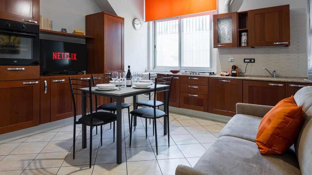una cucina con tavolo, sedie e divano di Inalpi Arena Suite Elegante Cromoterapia AC a Torino