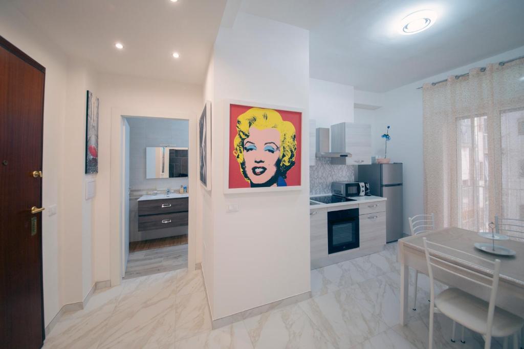 a kitchen with a painting of a woman on the wall at Gli Amici della Puglia in Taranto