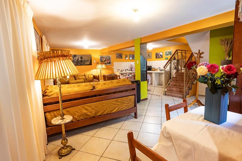 1 dormitorio con 1 cama y 1 mesa con lámpara en Cherry Cusco, en Cusco