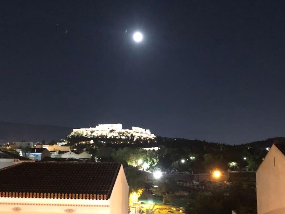 a view of a city at night with the moon at COMBO Acropolis view 6 bedrooms 4 bathrooms in Athens