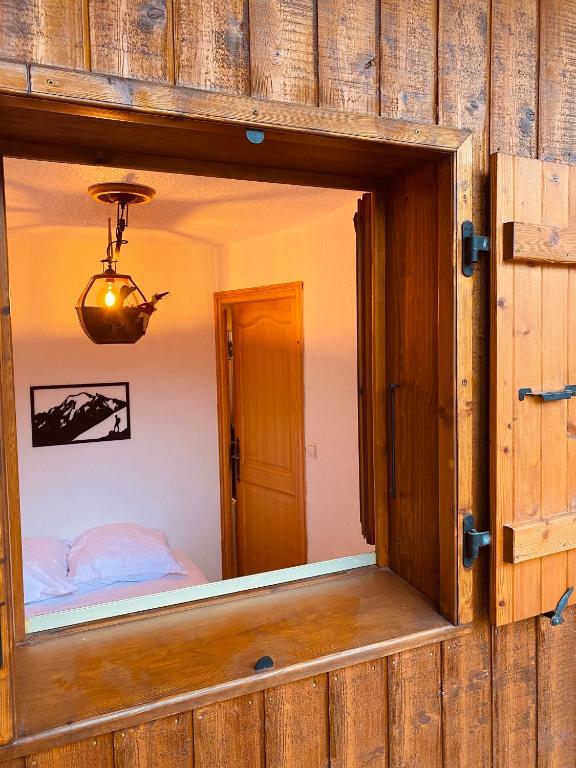 - une fenêtre dans une chambre avec un lit dans l'établissement Superbe studio Morillon Village / Samoëns, à Morillon