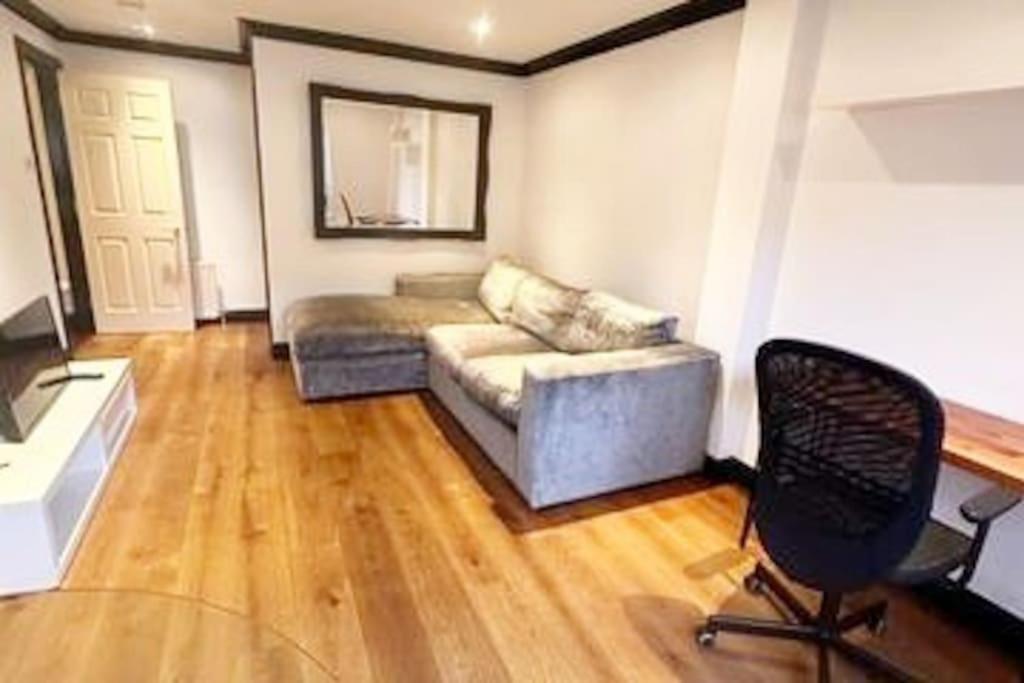 - un salon avec un canapé et une chaise dans l'établissement Stylish & Peaceful Covent Garden Apartment, à Londres