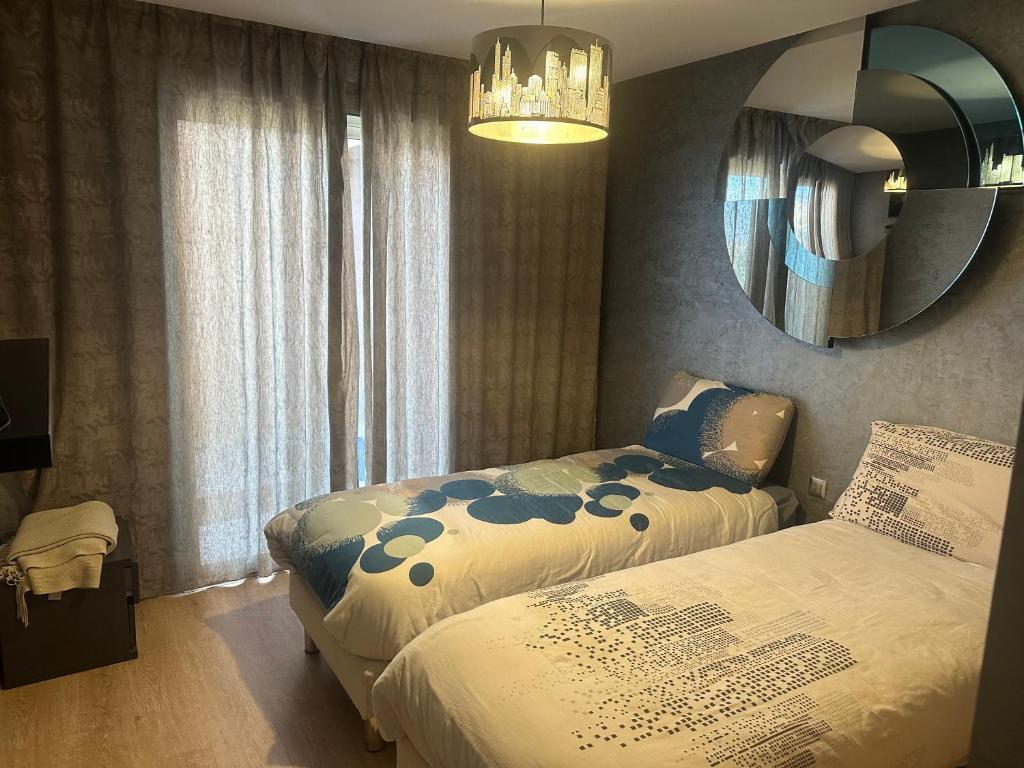 a bedroom with two beds and a mirror at Appartement golf prestigia in Marrakesh