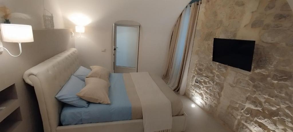 Dormitorio pequeño con cama y TV en Itinerario Barocco, en Ragusa