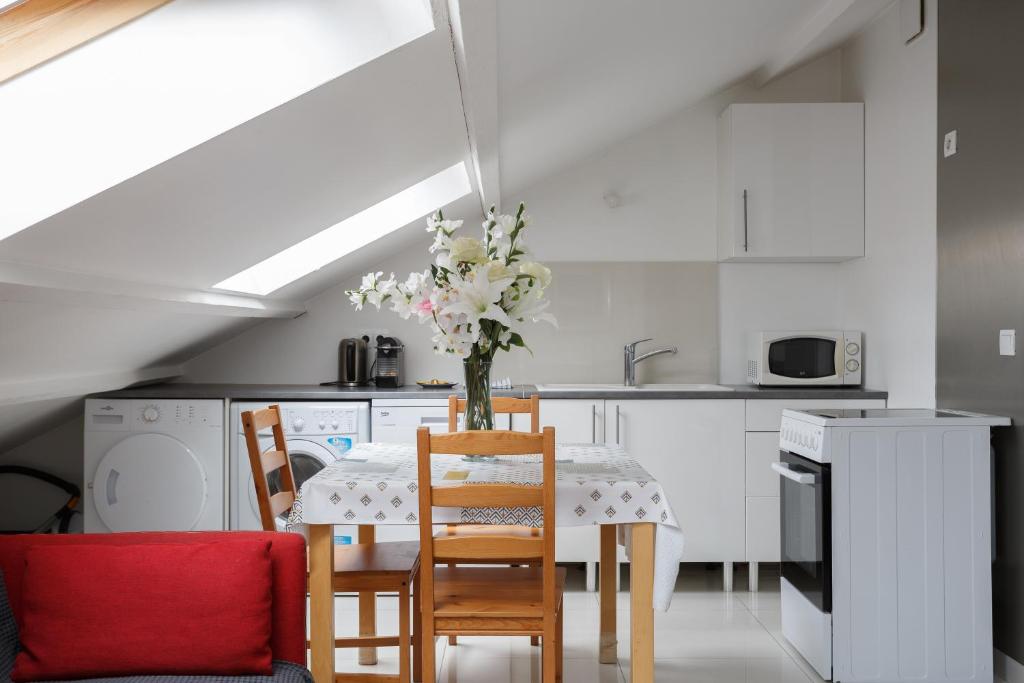 una cucina con tavolo e vaso di fiori di Le blanc gauche BAT A 3ème étage a Le Blanc-Mesnil