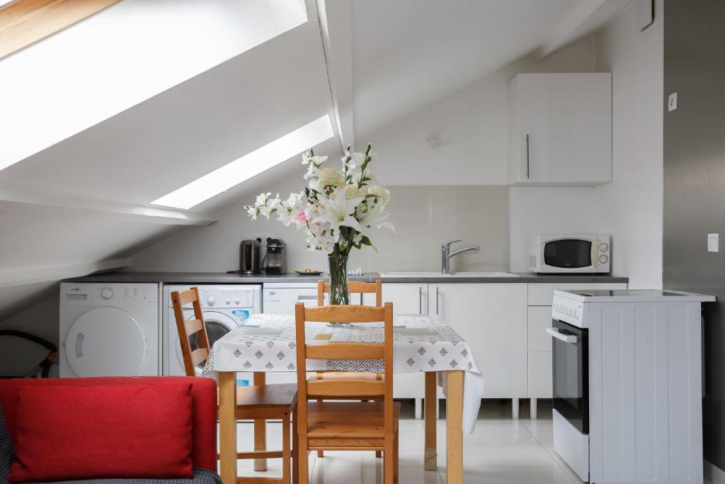 a kitchen with a table with a vase of flowers on it at Le blanc gauche BAT A 3ème étage in Le Blanc-Mesnil