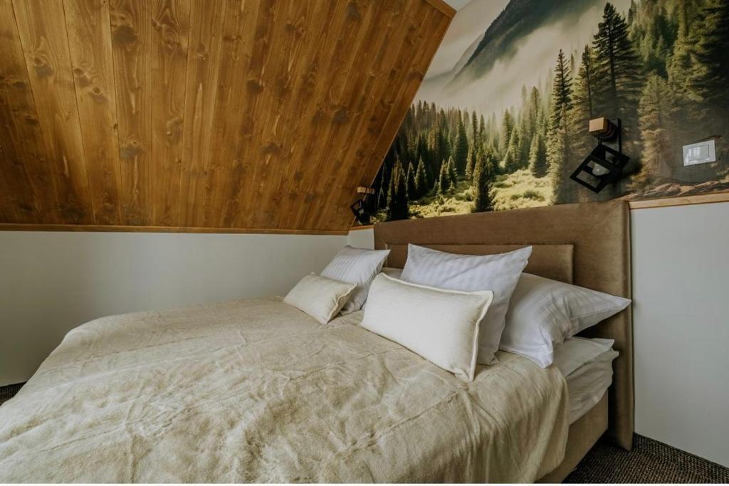 ビャウィ・ドゥナイェツにあるCichy Brzyzekのベッドルーム1室(壁に絵画が描かれたベッド1台付)
