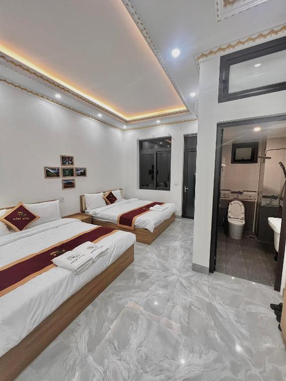 NẮNG HOTEL في Mù Cang Chải: غرفه فندقيه سريرين وحمام