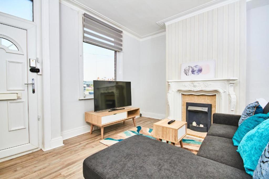 a living room with a couch and a fireplace at 5 minutes from Leeds City Centre - Parking in Leeds