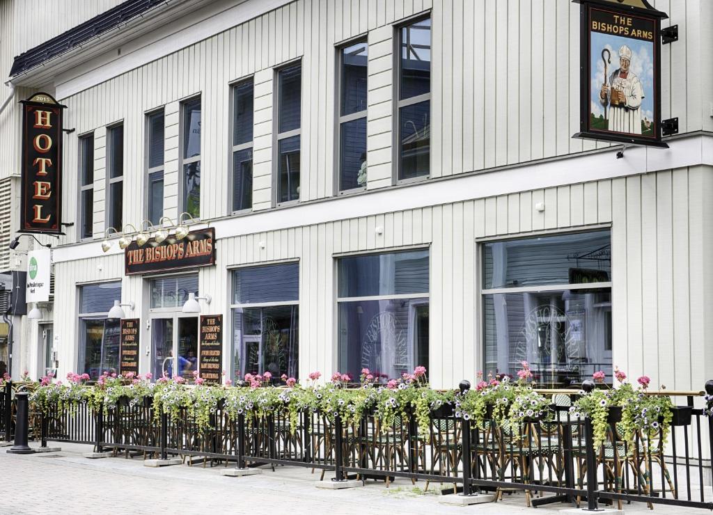 una fila di piante di fronte a un edificio di Hotel Bishops Arms Piteå a Piteå