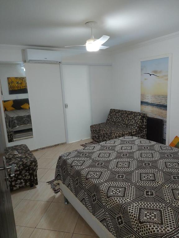 - une chambre avec un lit et un canapé dans l'établissement Pe na areia, à Angra dos Reis