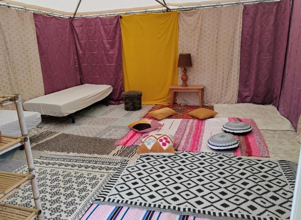 Cette chambre comprend une tente avec un lit et une table. dans l'établissement Tente Eco Lodge zen Bayonne, à Bayonne